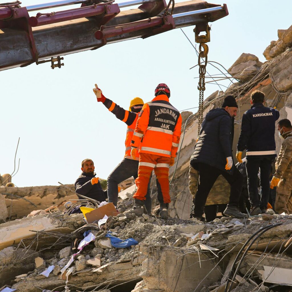 Rescue workers searching through rubble after an earthquake, showcasing teamwork and determination.